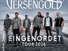 Sechs Bandmitglieder von Versengold stehen entschlossen am Strand, im Hintergrund das Meer.