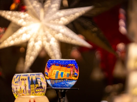 Christmas market Leuchtend bemalte Glaslichter vor einem großen Stern im Hintergrund auf dem Weihnachtsmarkt.Brightly painted glass lights in front of a large star in the background at the Christmas market.
