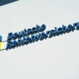 foto_logo_schriftzug.jpg Das Bild zeigt ein blau-gelbes Logo mit dem Schriftzug "Deutsche Rentenversicherung" an einer weißen Wand.