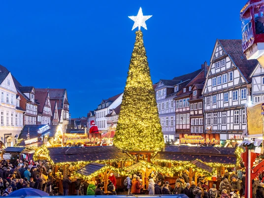 Weihnachtsmarkt Celle Weihnachtsmarkt in Celle: Leuchtender Tannenbaum, umgeben von Fachwerkhäusern und Menschenmenge.Christmas market in Celle: A glowing Christmas tree, surrounded by half-timbered houses and crowds of people.Julemarked i Celle: Et lysende juletræ omgivet af bindingsværkshuse og masser af mennesker.Kerstmarkt in Celle: Een gloeiende kerstboom omringd door vakwerkhuizen en mensenmassa's.