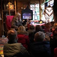 Erzählwerkstatt auf dem Weihnachtsmarkt Eine Frau liest einer Gruppe von Kindern in einer hölzernen Hütte auf dem Weihnachtsmarkt vor.A woman reads to a group of children in a wooden hut at the Christmas market.En kvinde læser op for en gruppe børn i en træhytte på julemarkedet.Een vrouw leest voor aan een groep kinderen in een houten hut op de kerstmarkt.