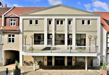 Das Stadttheater mit seiner modernen Fassade, flankiert von historischen Gebäuden, empfängt Besucher.