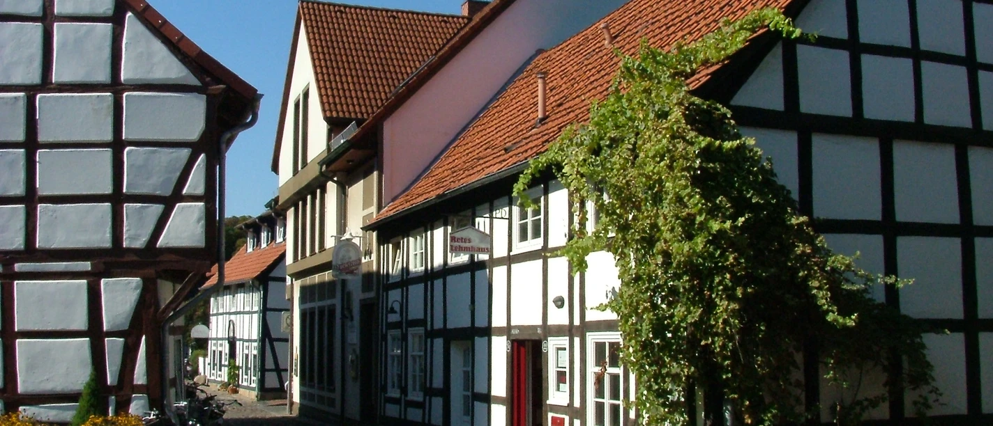 Mit allen Wassern Typische niedersächsische Fachwerkhäuser reihen sich entlang einer gepflasterten, ruhigen Gasse.