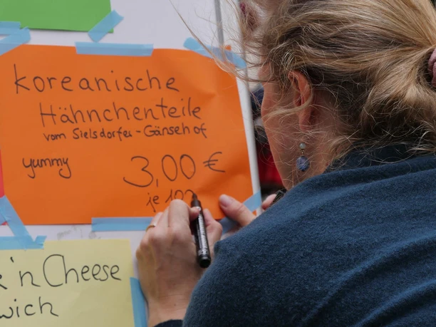 Block Party One person labels orange paper with "Korean chicken pieces", price 3 euros.