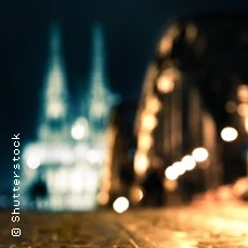 Zwei unscharfe, nächtlich beleuchtete Kirchtürme und eine erleuchtete Straße im Vordergrund.