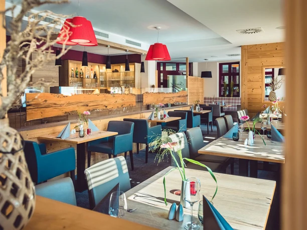 A modern restaurant with a wooden interior, elegant decorations and inviting lighting design.