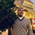 Der Gewinner von 2024: Max Dehning Max Dehning mit festlichem Hintergrund auf Weihnachtsmarkt, lächelnd mit Tanne.Max Dehning with festive background at Christmas market, smiling with fir tree.Max Dehning med festlig baggrund på julemarked, smilende med grantræ.Max Dehning met feestelijke achtergrond op kerstmarkt, lachend met dennenboom.