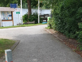 Zugang zum Wanderweg Leicht abschüssiger Zugang zum Wanderweg. Der Untergrund ist asphaltiert.