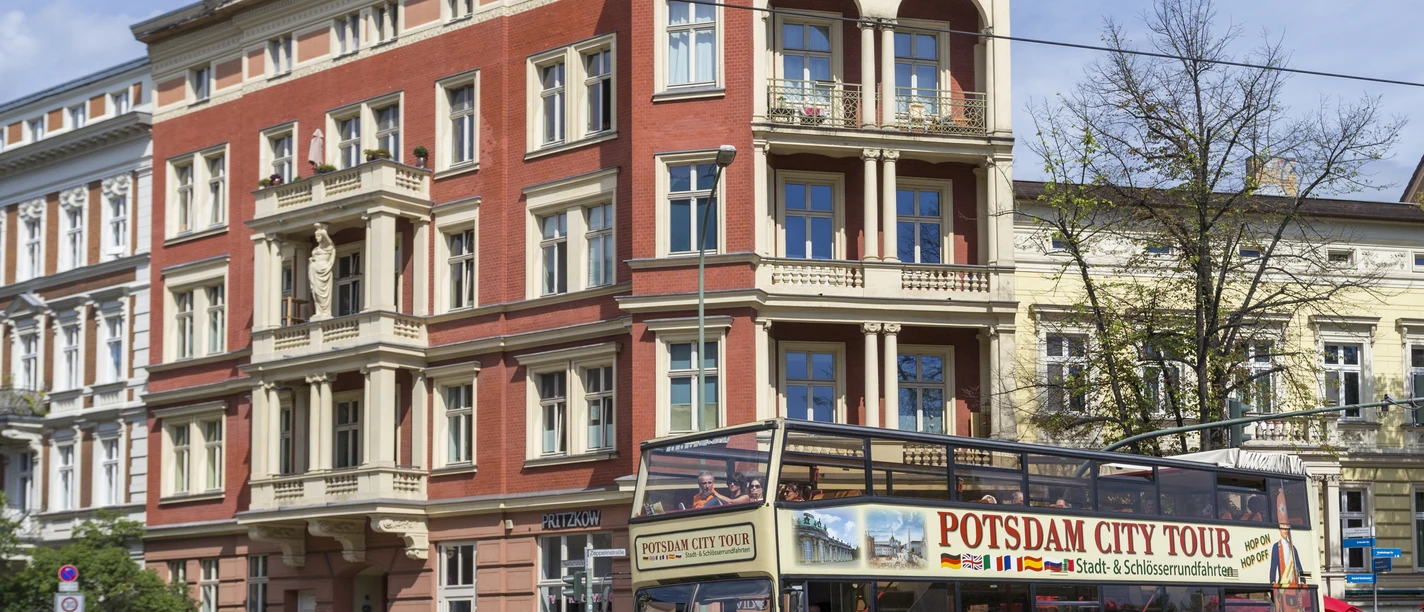 Stadtrundfahrt Alter Fritz Ein Bus der "Stadtrundfahrt Alter Fritz" biegt um eine Ecke in Potsdam