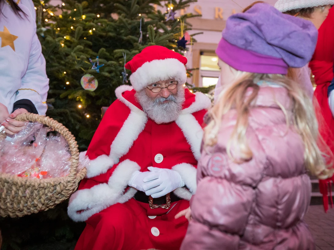 Nikolausaktion in Celle Ein Mann in Nikolaus-Kostüm unterhält sich mit einem Kind zu Weihnachten.