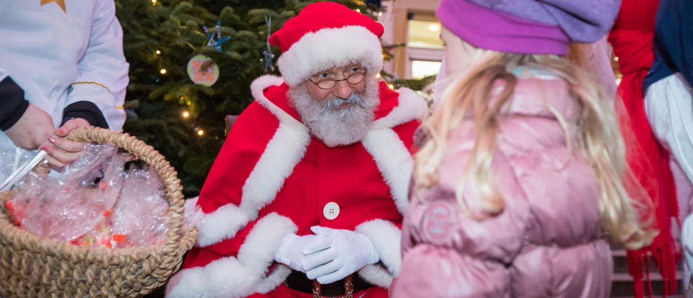 Nikolausaktion in Celle Ein Mann in Nikolaus-Kostüm unterhält sich mit einem Kind zu Weihnachten.