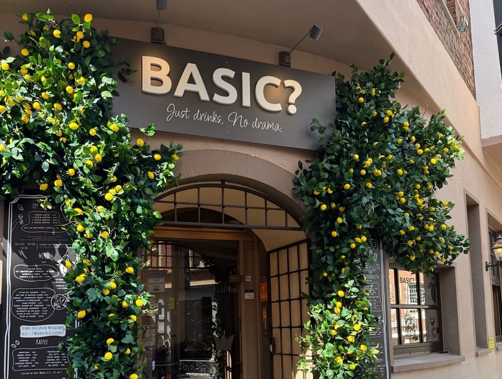 Bogenförmiger Eingang der BASIC? Gastrobar, flankiert von Zitronenbäumchen.