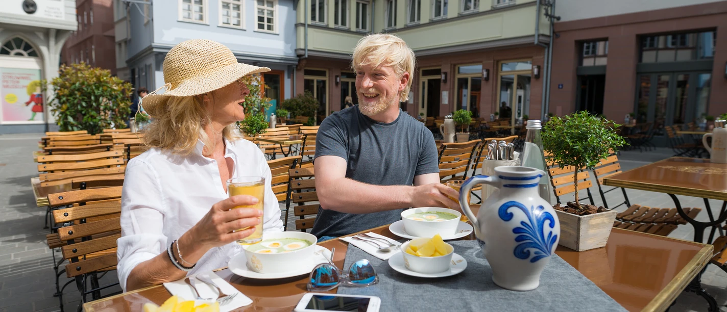 Apfelwein für Fortgeschrittene Paar genießt Apfelwein im Café in Frankfurts Altstadt bei Sonnenschein.
