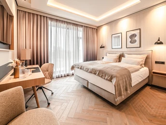 Hotelzimmer Fensterblick Modernes Hotelzimmer mit Doppelbett, Schreibtisch, warmem Licht und Blick durch bodentiefe Fenster.