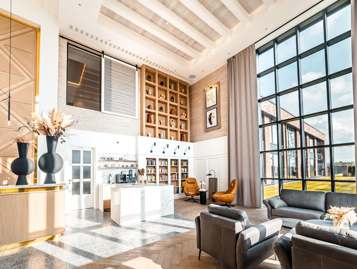 Hotellobby Helle Hotellobby mit hohen Fenstern, modernen Sitzmöbeln und stilvollen Dekorationselementen