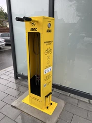 ADAC Radservice-Station Radservice-Station aus leuchtend gelbem Stahl mit Werkzeughalterung und QR-Codes.