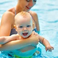 Baby u. Kleinkinderschwimmen im Koppke Greetsiel Zu sehen ist ein Baby auf dem Arm der Mutter im Schwimmbecken