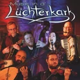 Titelbild Musik in der Lüchterkark.jpg Auf dem Bild ist eine Gruppe von Musikern mit traditionellen Instrumenten vor einem beleuchteten Hintergrund.