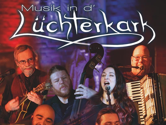 Titelbild Musik in der Lüchterkark.jpg Auf dem Bild ist eine Gruppe von Musikern mit traditionellen Instrumenten vor einem beleuchteten Hintergrund.