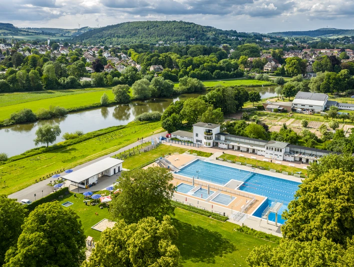Hoexter-Freibad-Teutoburger-Wald-Stadt-Hoexter-D-Ketz-219-CC-BY-SA.jpg Luftaufnahme des Freibads Höxter im Grünen, umgeben von Bäumen und nahe am Fluss gelegen.