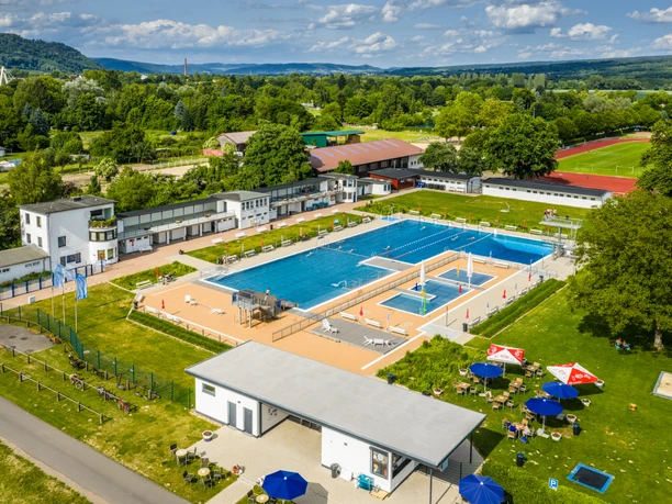 Großes Freibad in Höxter mit mehreren Schwimmbecken, Liegewiesen und umgebender Natur.