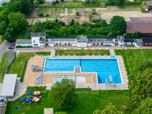 Hoexter-Freibad-Teutoburger-Wald-Stadt-Hoexter-D-Ketz-208-CC-BY-SA.jpg Freibad in Höxter mit zwei großen Schwimmbecken, umgeben von grünen Wiesen und Sonnenschirmen.