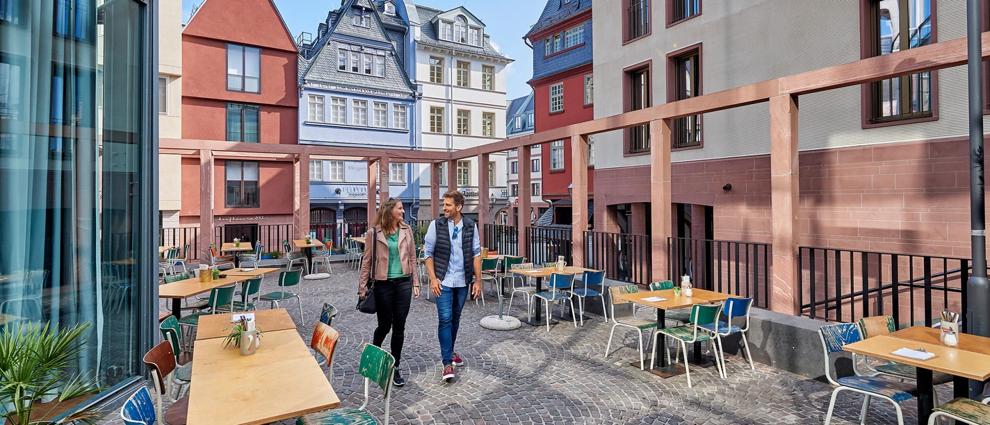 The old town experience Couple strolls through a modern café in Frankfurt's historic old town.