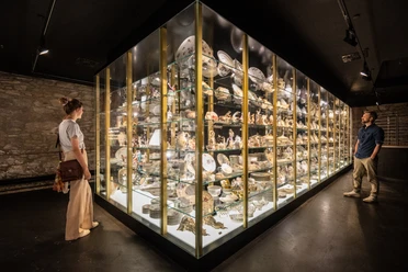 Museumsausstellung im Schloss Fürstenberg mit vielfältigen Porzellanobjekten, Besucher betrachten Vitrine.
