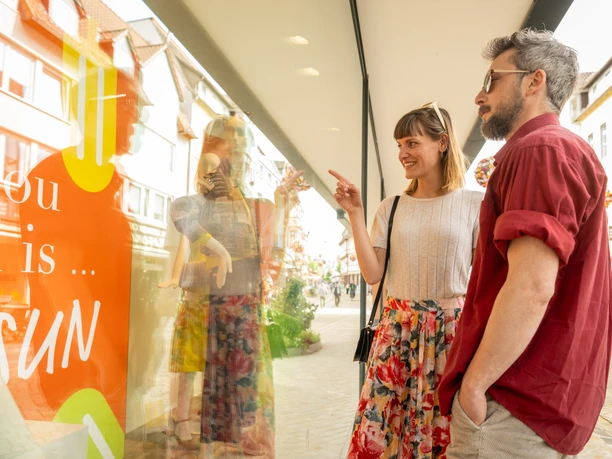 Hoexter-Marktstraße-Shopping-Teutoburger-Wald-Stadt-Hoexter-D-Ketz-059.jpg Ein Paar betrachtet eine Schaufensterpuppe in der Marktstraße von Höxter. Sie wirken interessiert.