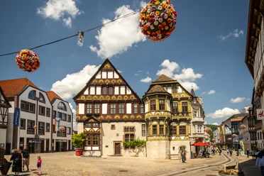 Hoexter-Marktstraße-Weserrenaissance-Teutoburger-Wald-Stadt-Hoexter-D-Ketz-103.jpg Historische Gebäude in der Marktstraße von Höxter mit Fachwerkhäusern unter blauem Himmel.