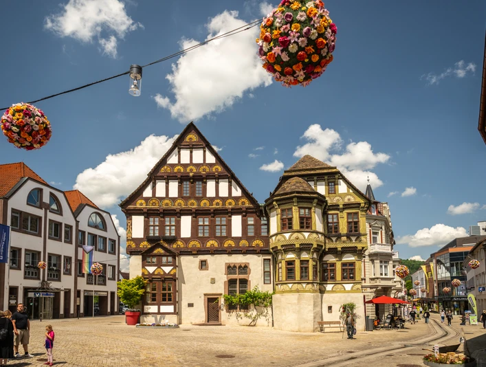 Hoexter-Marktstraße-Weserrenaissance-Teutoburger-Wald-Stadt-Hoexter-D-Ketz-103.jpg Historische Gebäude in der Marktstraße von Höxter mit Fachwerkhäusern unter blauem Himmel.