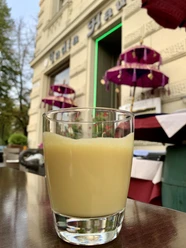 Altstadt Genusstour Ein mit Mango-Lassi gefüllten Glas steht auf einem Tisch im Außenbereich eines Restaurants.