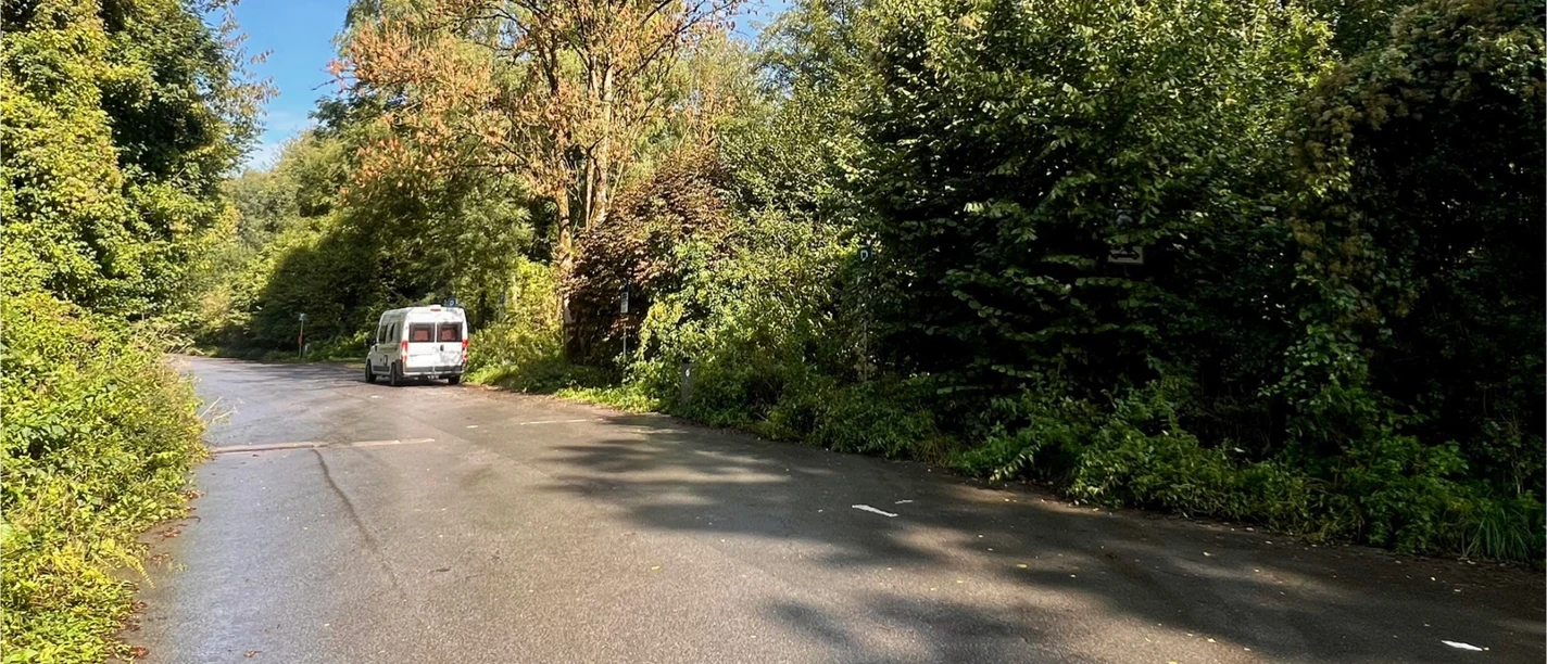 Wohnmobilstellplatz am Steinbruch in Haan-Gruiten Wohnmobil-Stellplatz an einer von Bäumen umgebenen Straße in Haan-Gruiten.