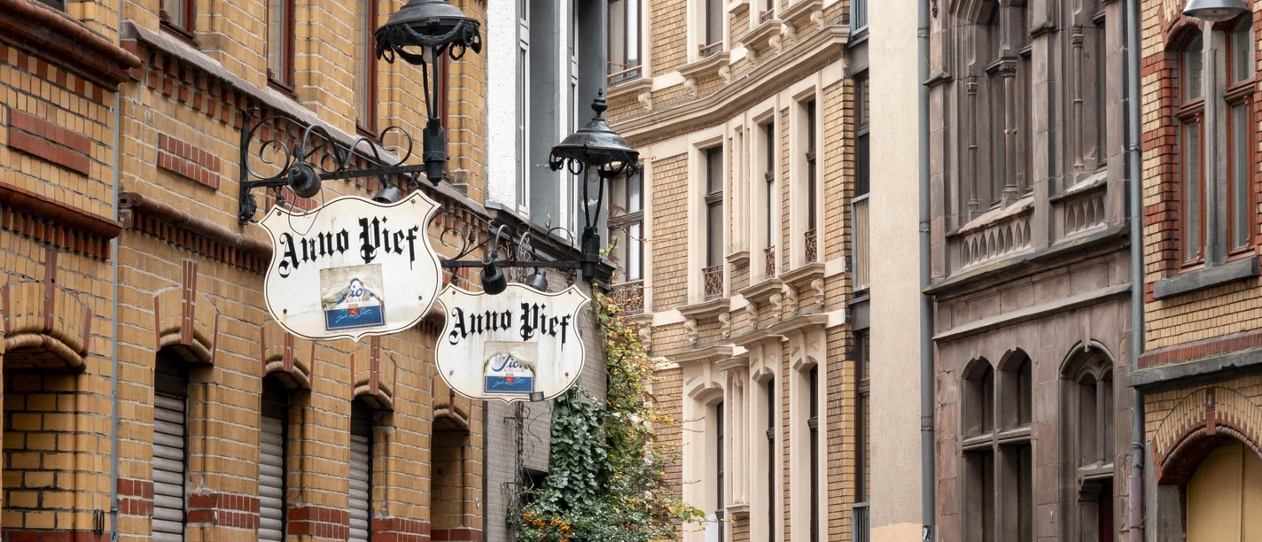 Gepflasterte Straße mit historischen Gebäuden und Laternen in einer ruhigen Altstadt-Straße.