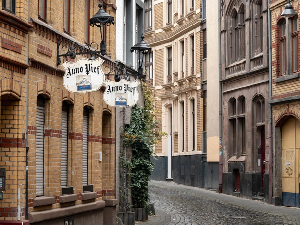 In the Stavenhof on the Eigelstein Cobbled street with historic buildings and lanterns in a quiet old town street.