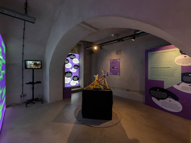View of the exhibition A modern exhibition space with interactive panels and lighting in a vaulted arch.