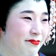 Pressebild Japan - Geisha.jpg Nahaufnahme einer Person mit traditionellem weißen Make-up, rotem Lippenstift und Haarschmuck