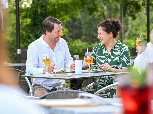 Café Ruhrnatur, Mülheim an der Ruhr Ein Paar genießt an einem Sommertag ein Getränk im Freien. Es wird gelacht und sich unterhalten.