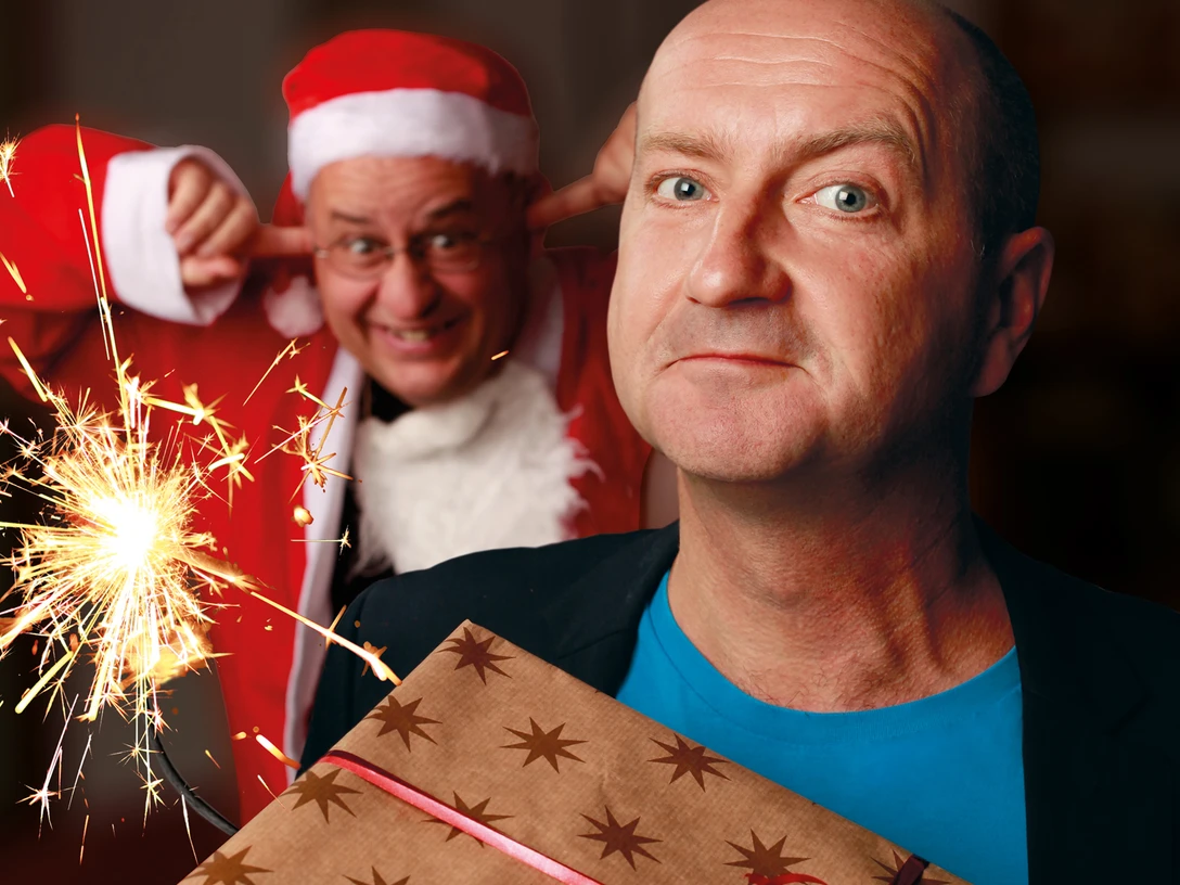 251206_SchwGruetze.jpg Ein Mann hält ein Geschenk vor seinem Oberteil, während im Hintergrund eine Person im Weihnachtsmannkostüm mit einem schalkhaften Ausdruck die Ohren zuhält. Eine Wunderkerze sprüht funkelndes Licht.A man holds a present in front of his top, while in the background a person in a Santa Claus costume covers his ears with a mischievous expression. A sparkler sprays sparkling light.Muž drží před svým vrškem dárek, zatímco v pozadí si osoba v kostýmu Otce Vánoc se zlomyslným výrazem zakrývá uši. Z prskavky stříká jiskřivé světlo.Mężczyzna trzyma prezent przed blatem, podczas gdy w tle osoba w stroju świątecznym zakrywa uszy z psotnym wyrazem twarzy. Świecznik rozpyla iskrzące się światło.Een man houdt een cadeautje voor zijn topje, terwijl op de achtergrond een persoon in kerstkostuum zijn oren bedekt met een ondeugende uitdrukking. Een fonkelaar verspreidt fonkelend licht.Un uomo tiene un regalo davanti alla testa, mentre sullo sfondo una persona in costume da Babbo Natale si copre le orecchie con un'espressione maliziosa. Uno sparkler spruzza luce scintillante.