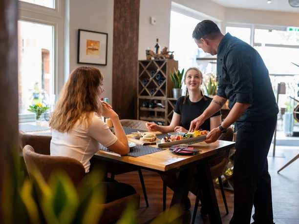 Eutin-Gastronomie-Stumpfes Eck-Essen.jpg Zwei Freundinnen bekommen im Bistro Stumpfes Eck in Eutin ihr Essen serviert
