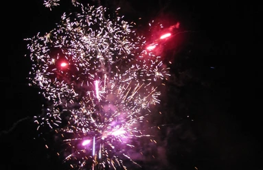 Feuerwerk Farbenfrohes Feuerwerk mit rosa und lila Funken erleuchtet den Nachthimmel in lebendigem Glanz.
