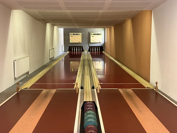 Twee moderne bowlingbanen met houten vloeren en digitale scoreborden in een restaurant.