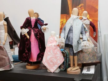 Holzfiguren tragen barocke, prachtvoll verzierte Kleider aus verschiedenen Materialien.