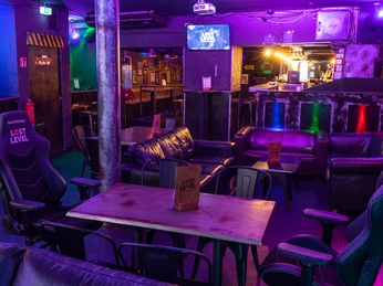 Gaming Area Gaming room with neon lights, gaming chairs and bar area in purple light.