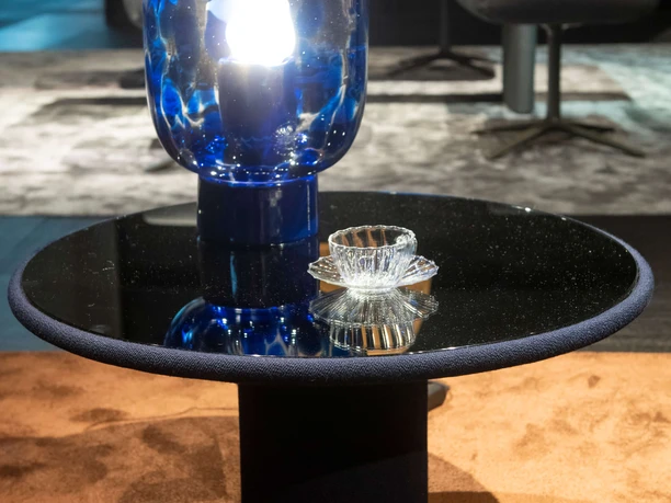 idd cologne: Koelnmesse GmbH, Thomas Klerx A table made of black glass with a blue lamp and crystal ashtray.