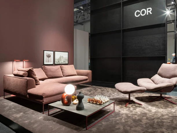 idd cologne High-quality living room furniture in warm earth tones: sofa, table lamp, chess set and armchair.