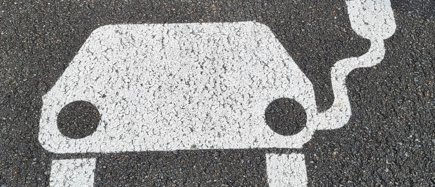 EAutoAufAsphalt.jpg Symbol E-Auto mit Aufladekabel auf Asphalt