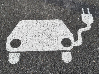 EAutoAufAsphalt.jpg Symbol E-Auto mit Aufladekabel auf Asphalt