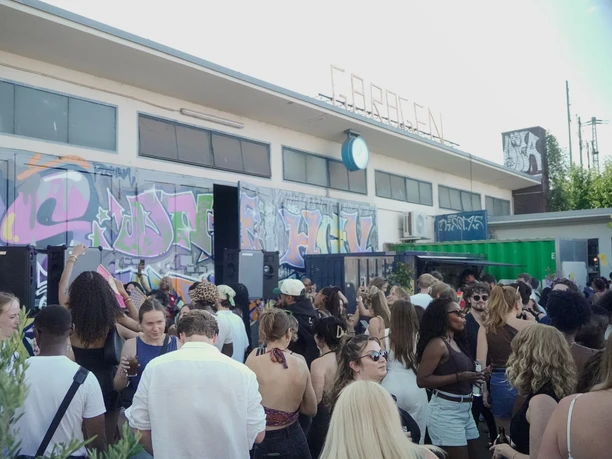 Garagen Club Ein lebendiger Ort voll Menschen, Graffitikunst und urbanem Flair.