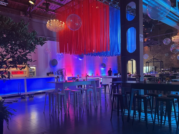 BALLONI Halle_8 Moderne Eventhalle mit hohen Decken, bunter Beleuchtung und dekorativen Elementen im Ballsaal.